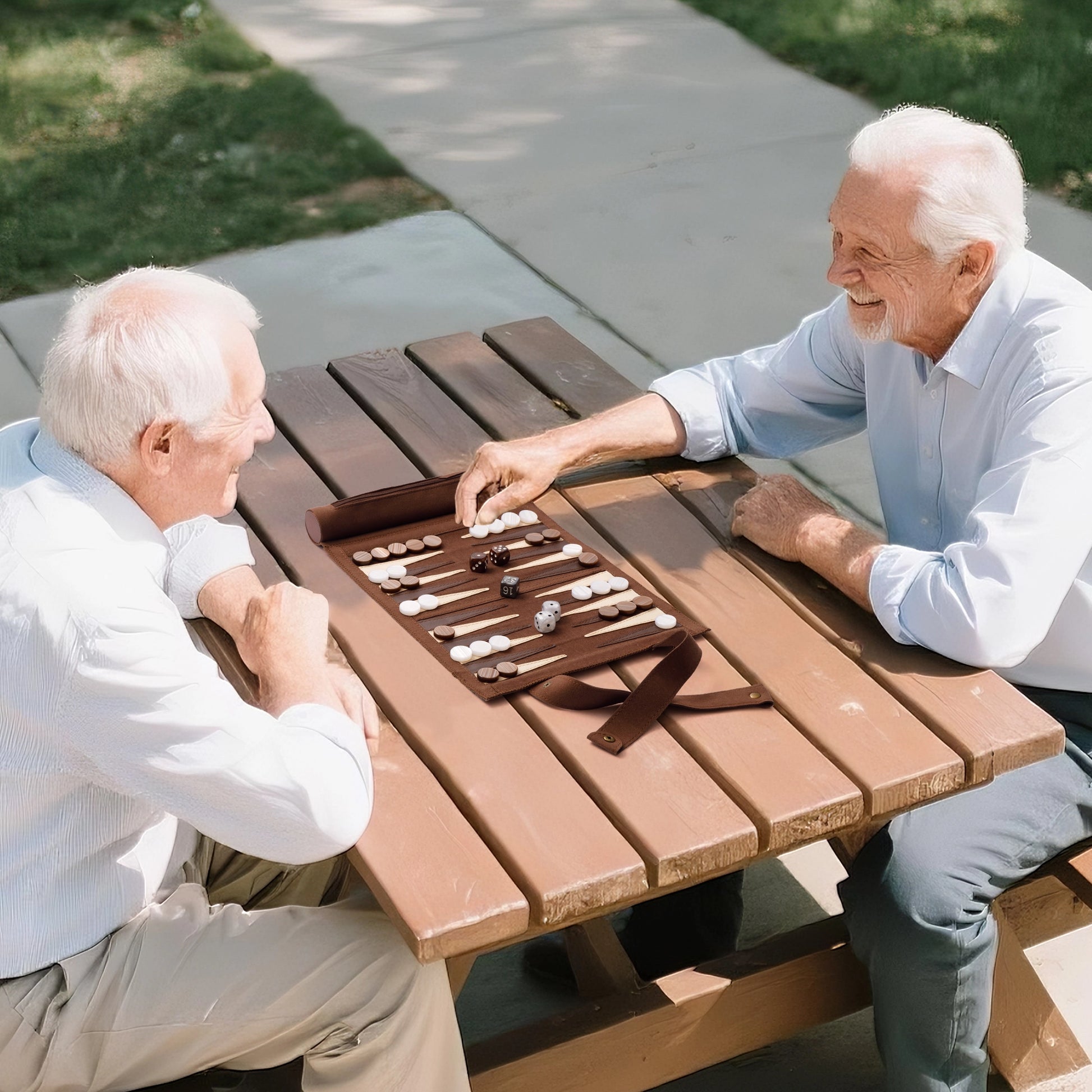 Two seniors playing backgammon on brown 3-in-1 travel game set at park bench, perfect for family and senior entertainment.