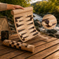 Woodronic roll-up backgammon set unrolled on a wooden table by a river, with a close-up of magnetic game pieces, showcasing portability.