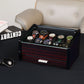 Ebony wood watch box with glass top displayed on a desk, showcasing luxury design and functional storage for watches and accessories.