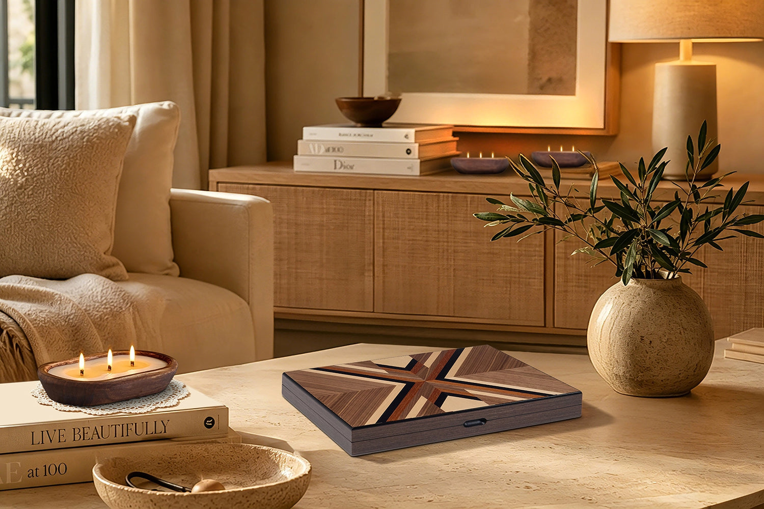 Artistic wood inlay backgammon set displayed on a travertine coffee table, paired with a candle and olive branch, perfect for modern rustic home decor.